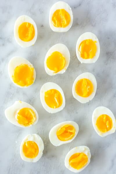 Several Instant Pot soft boiled eggs cut in half on a marble slab.