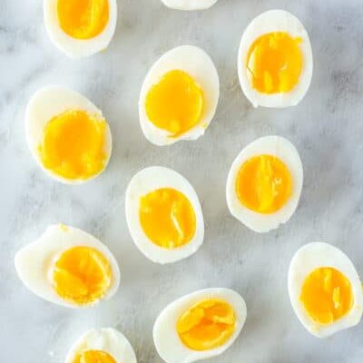 Several Instant Pot soft boiled eggs cut in half on a marble slab.